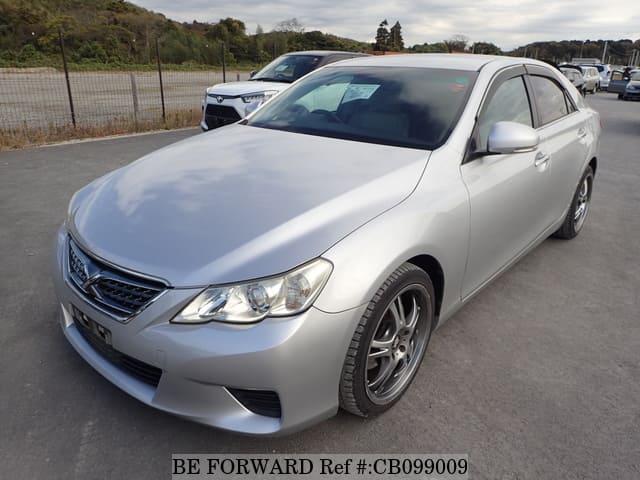A grey JDM sports car speeding down a highway at night.