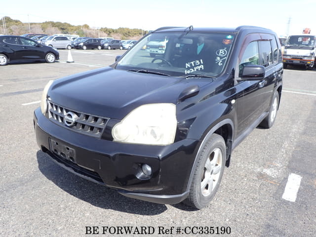A grey sports car speeding down a highway at night.