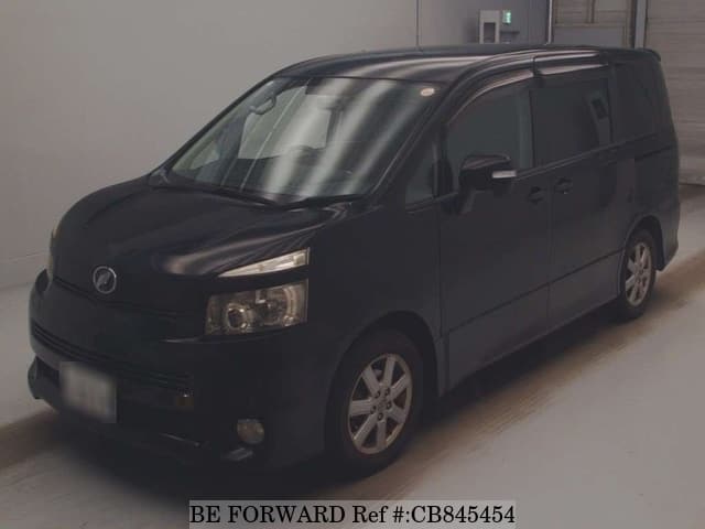 A grey JDM sports car speeding down a highway at night.