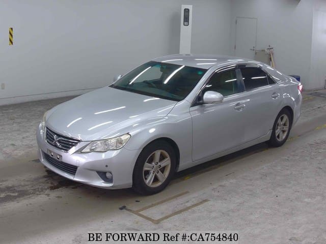 A grey JDM sports car speeding down a highway at night.