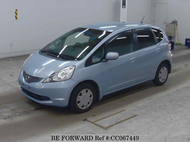 A grey sports car speeding down a highway at night.