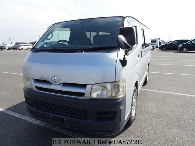 A grey JDM sports car speeding down a highway at night.