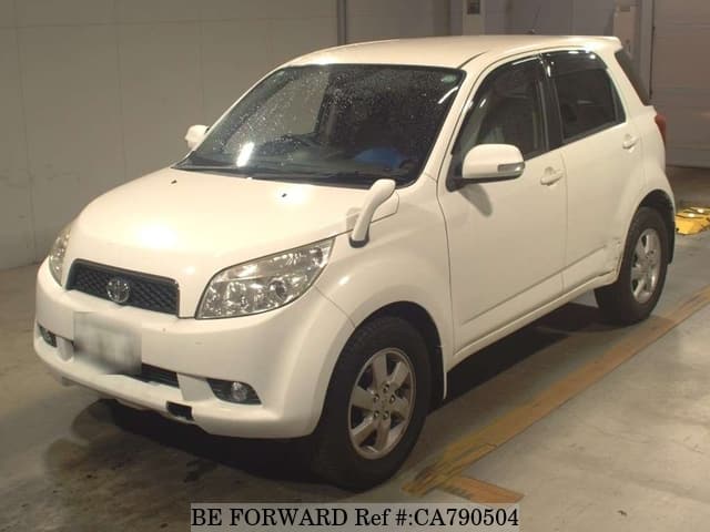 A grey JDM sports car speeding down a highway at night.