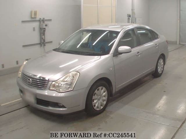 A grey sports car speeding down a highway at night.
