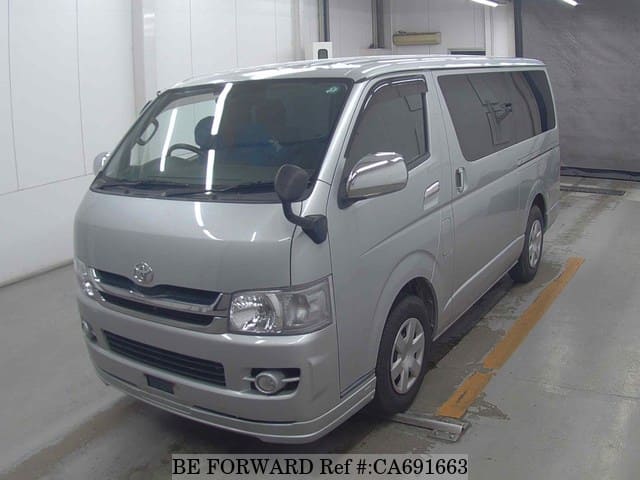 A grey JDM sports car speeding down a highway at night.