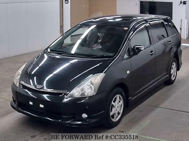 A grey sports car speeding down a highway at night.