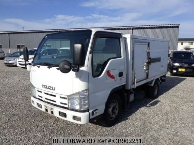 A grey sports car speeding down a highway at night.