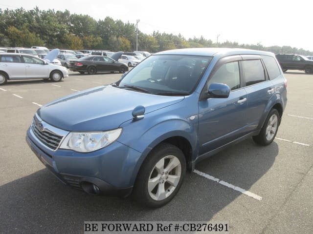 A grey JDM sports car speeding down a highway at night.