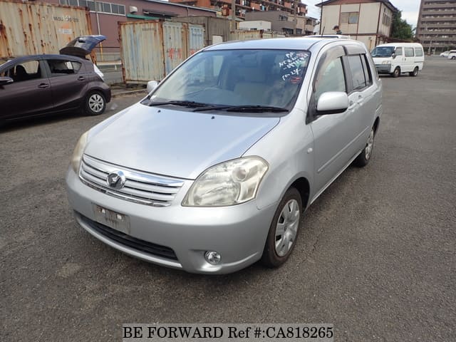 A grey JDM sports car speeding down a highway at night.