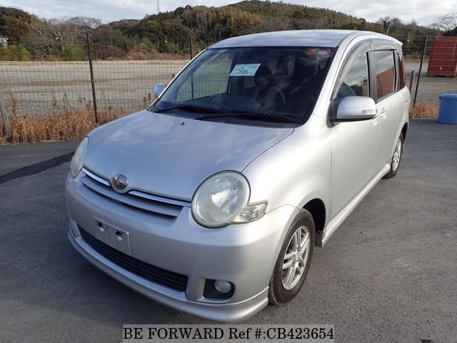A grey JDM sports car speeding down a highway at night.