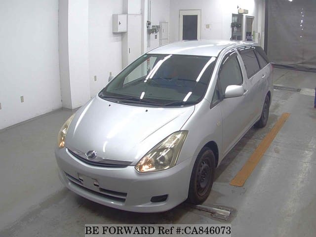 A grey JDM sports car speeding down a highway at night.
