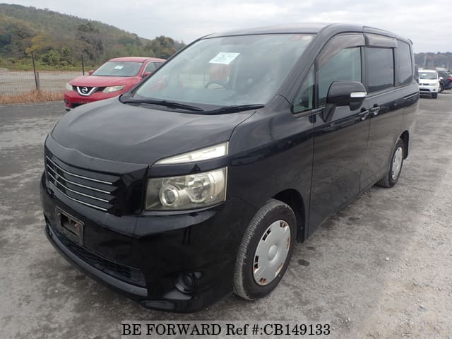 A grey JDM sports car speeding down a highway at night.