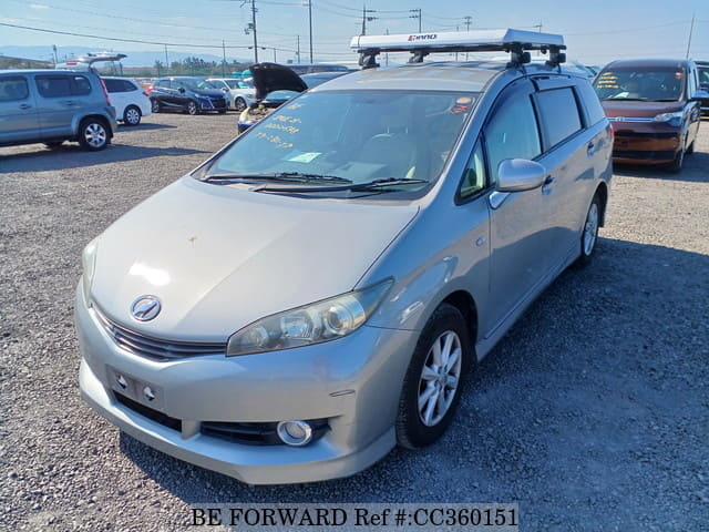 A grey sports car speeding down a highway at night.