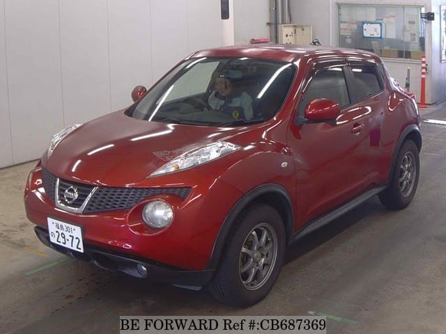 A grey sports car speeding down a highway at night.