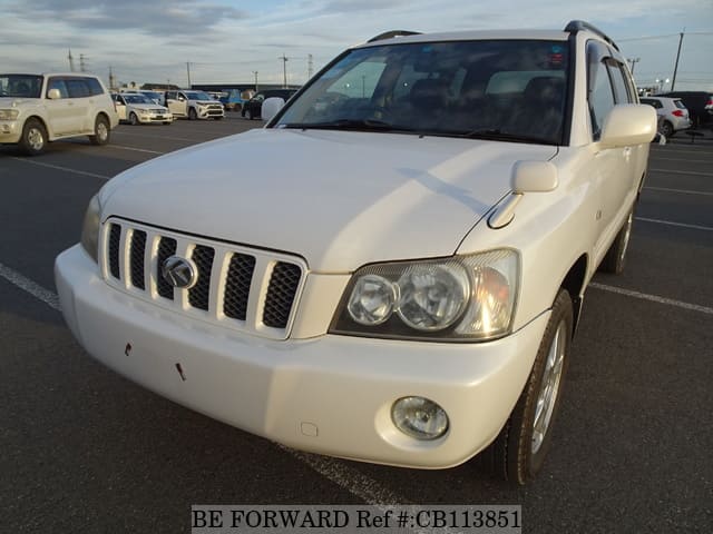 A grey JDM sports car speeding down a highway at night.