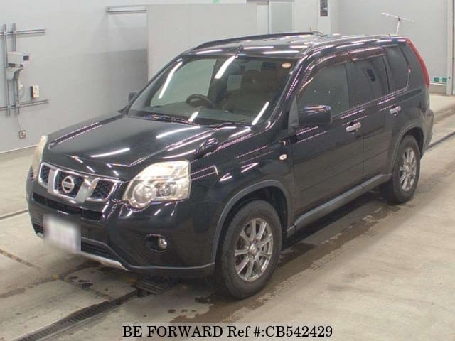 A grey sports car speeding down a highway at night.