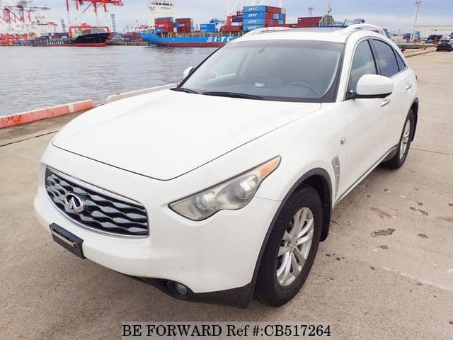 A grey JDM sports car speeding down a highway at night.