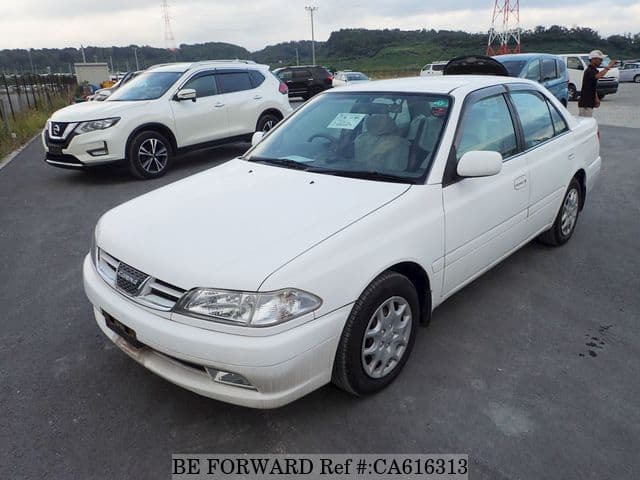 A grey JDM sports car speeding down a highway at night.
