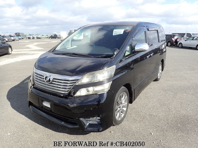 A grey sports car speeding down a highway at night.