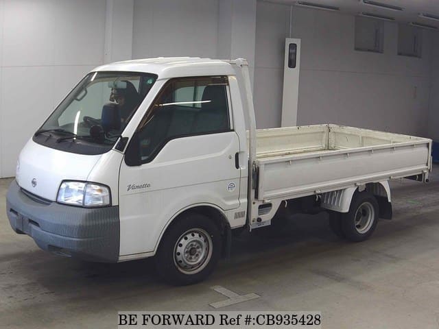 A grey sports car speeding down a highway at night.