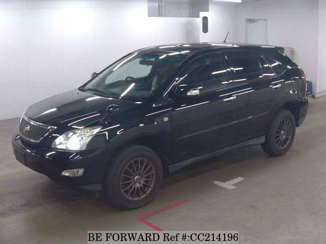 A grey sports car speeding down a highway at night.