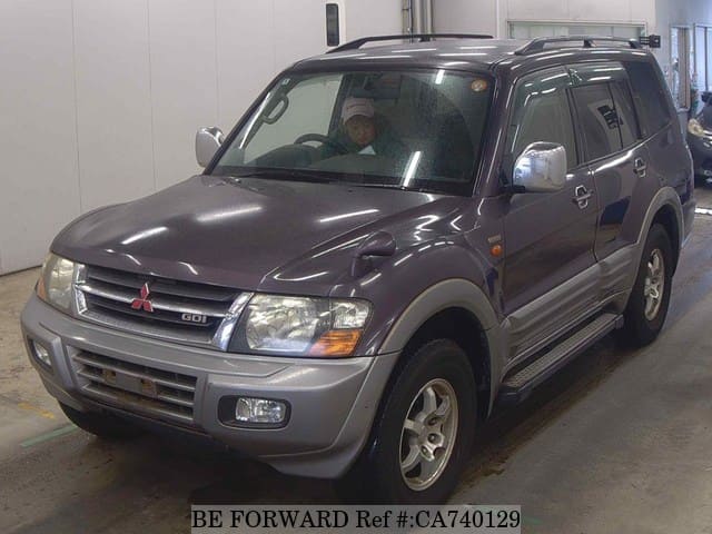 A grey JDM sports car speeding down a highway at night.