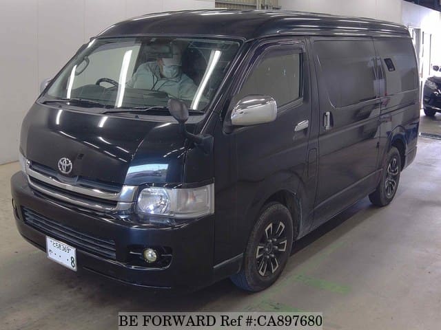 A grey JDM sports car speeding down a highway at night.