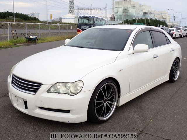 A grey JDM sports car speeding down a highway at night.