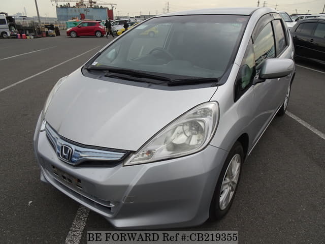 A grey JDM sports car speeding down a highway at night.