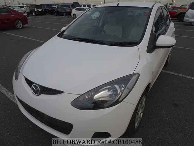 A grey sports car speeding down a highway at night.