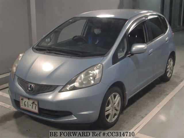 A grey sports car speeding down a highway at night.