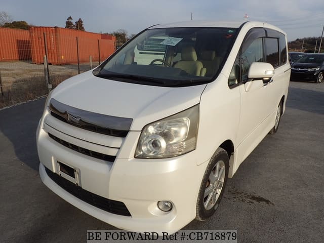 A grey JDM sports car speeding down a highway at night.