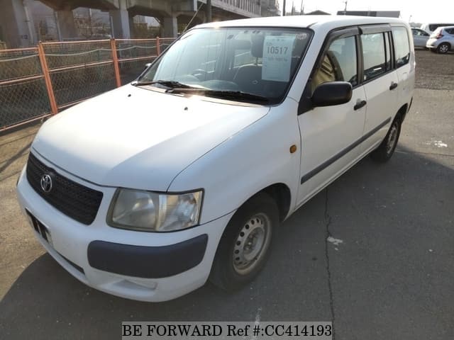 A grey sports car speeding down a highway at night.