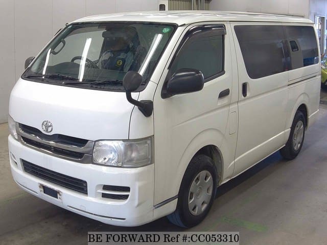 A grey sports car speeding down a highway at night.