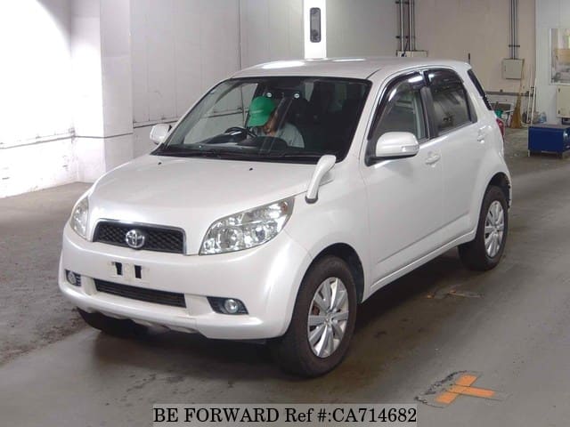 A grey JDM sports car speeding down a highway at night.