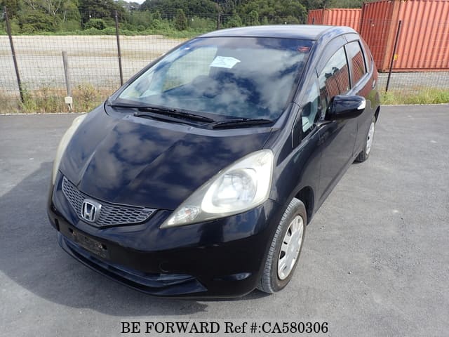 A grey JDM sports car speeding down a highway at night.