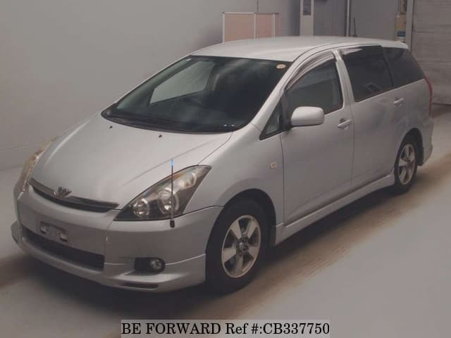 A grey JDM sports car speeding down a highway at night.