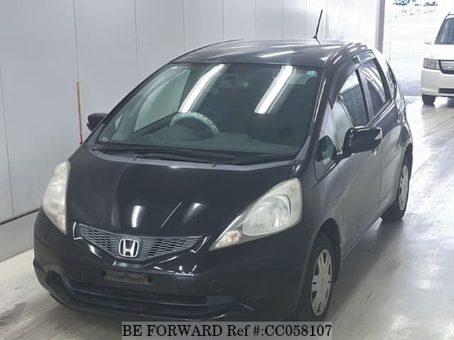 A grey sports car speeding down a highway at night.
