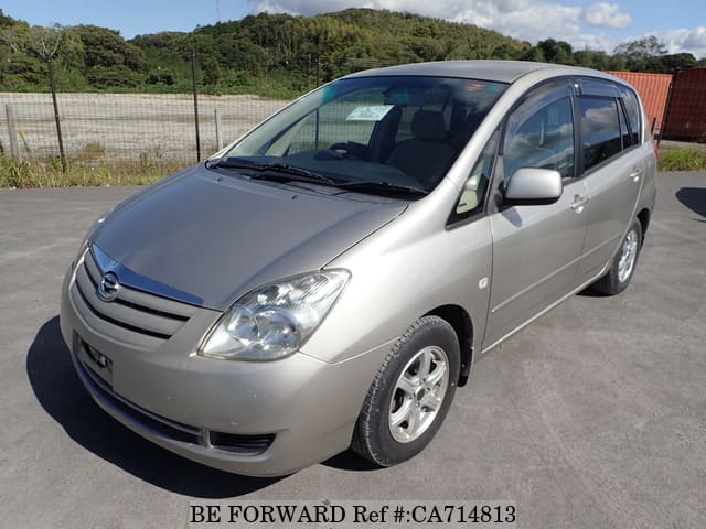 A grey JDM sports car speeding down a highway at night.