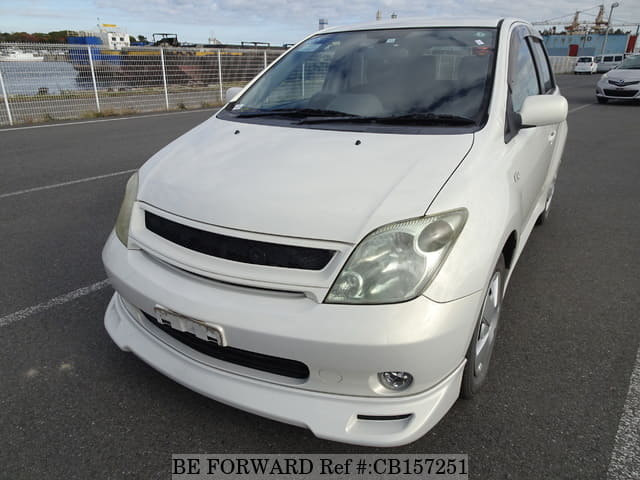 A grey JDM sports car speeding down a highway at night.