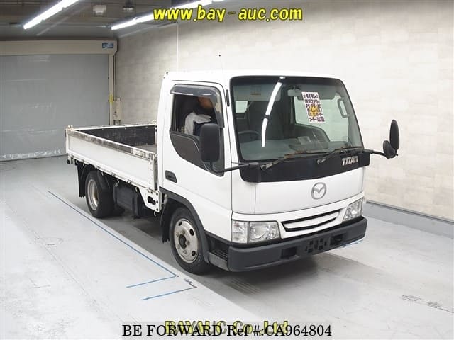 A grey JDM sports car speeding down a highway at night.