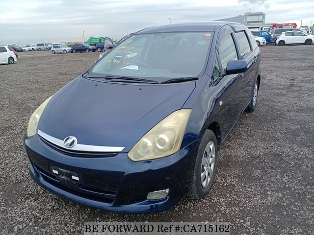 A grey JDM sports car speeding down a highway at night.