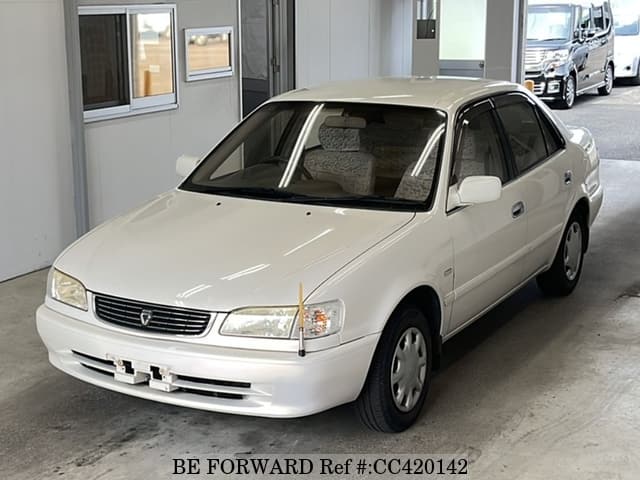 A grey JDM sports car speeding down a highway at night.