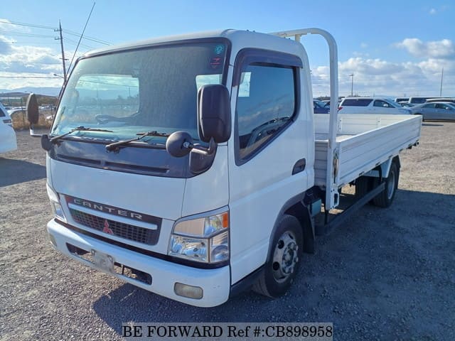 A grey sports car speeding down a highway at night.
