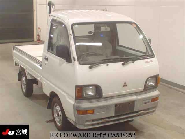 A grey JDM sports car speeding down a highway at night.