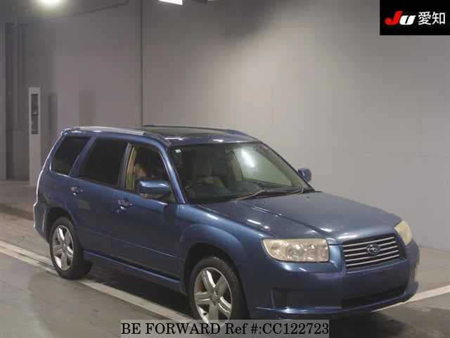 A grey sports car speeding down a highway at night.