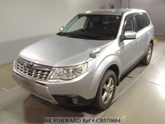 A grey JDM sports car speeding down a highway at night.