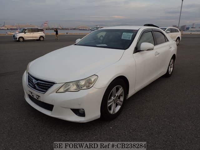 A grey JDM sports car speeding down a highway at night.