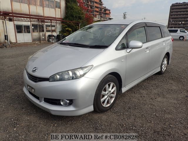 A grey JDM sports car speeding down a highway at night.