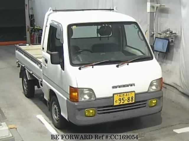 A grey sports car speeding down a highway at night.